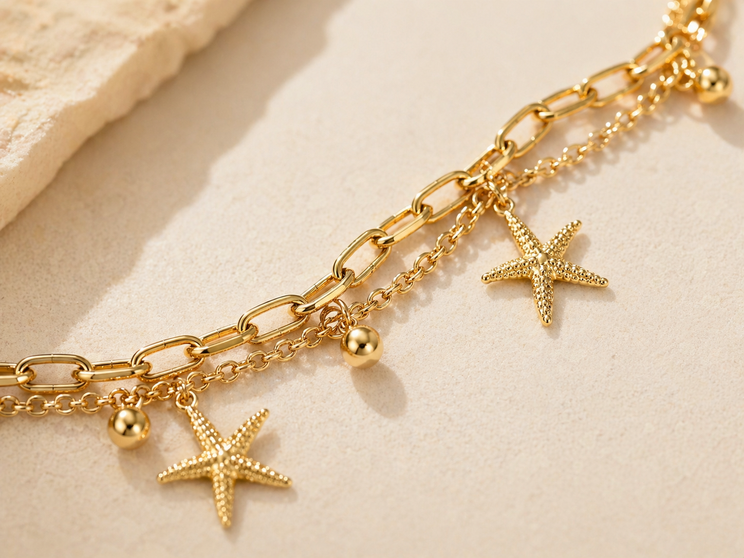 close up of 14K gold layered star charm bracelet showing star details and shine