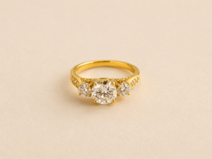 14K Gold Laminated three stone engagement ring with brilliant center stone and side stones front view